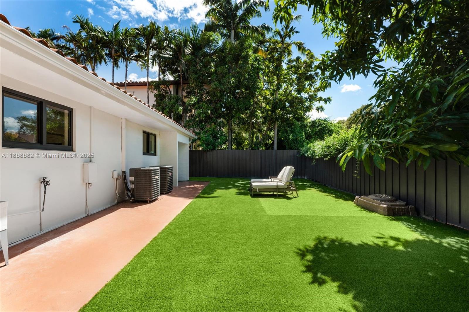 420 Southwest 19th Road Miami, FL 33129 - Photo 23 of 32 a view of a backyard with table and chairs potted plants and wooden fence