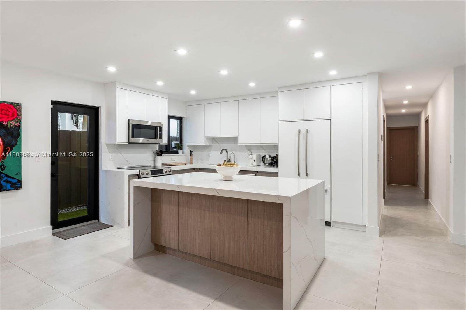 420 Southwest 19th Road Miami, FL 33129 - Photo 5 of 32 a kitchen with kitchen island a sink stainless steel appliances and cabinets