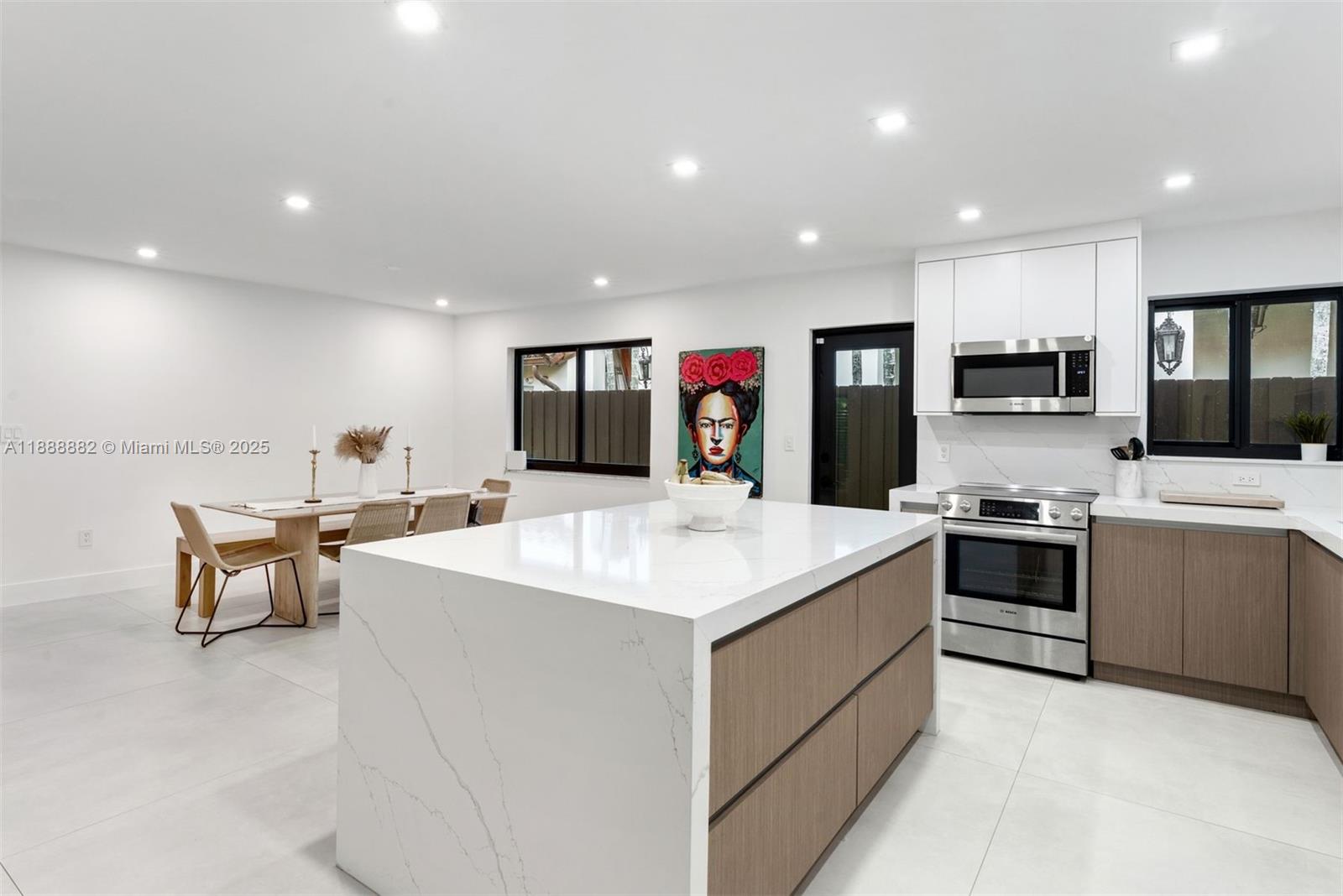 420 Southwest 19th Road Miami, FL 33129 - Photo 6 of 32 a large white kitchen with stainless steel appliances kitchen island a stove and a sink