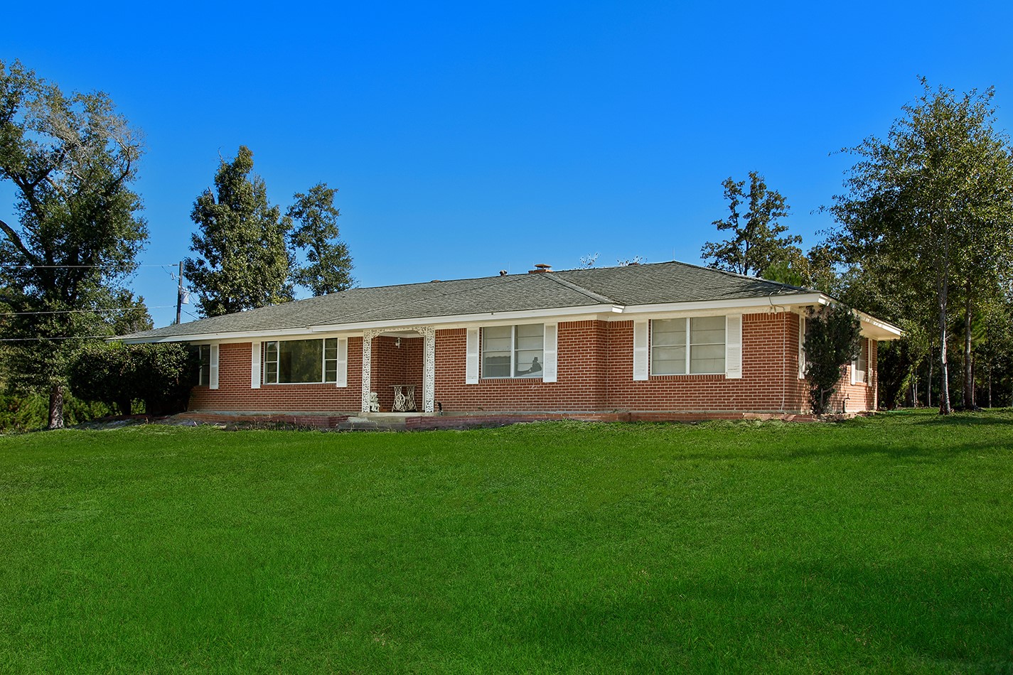 7185 Highway 75 Huntsville, TX 77340 - Photo 2 of 33 a front view of a house with a garden