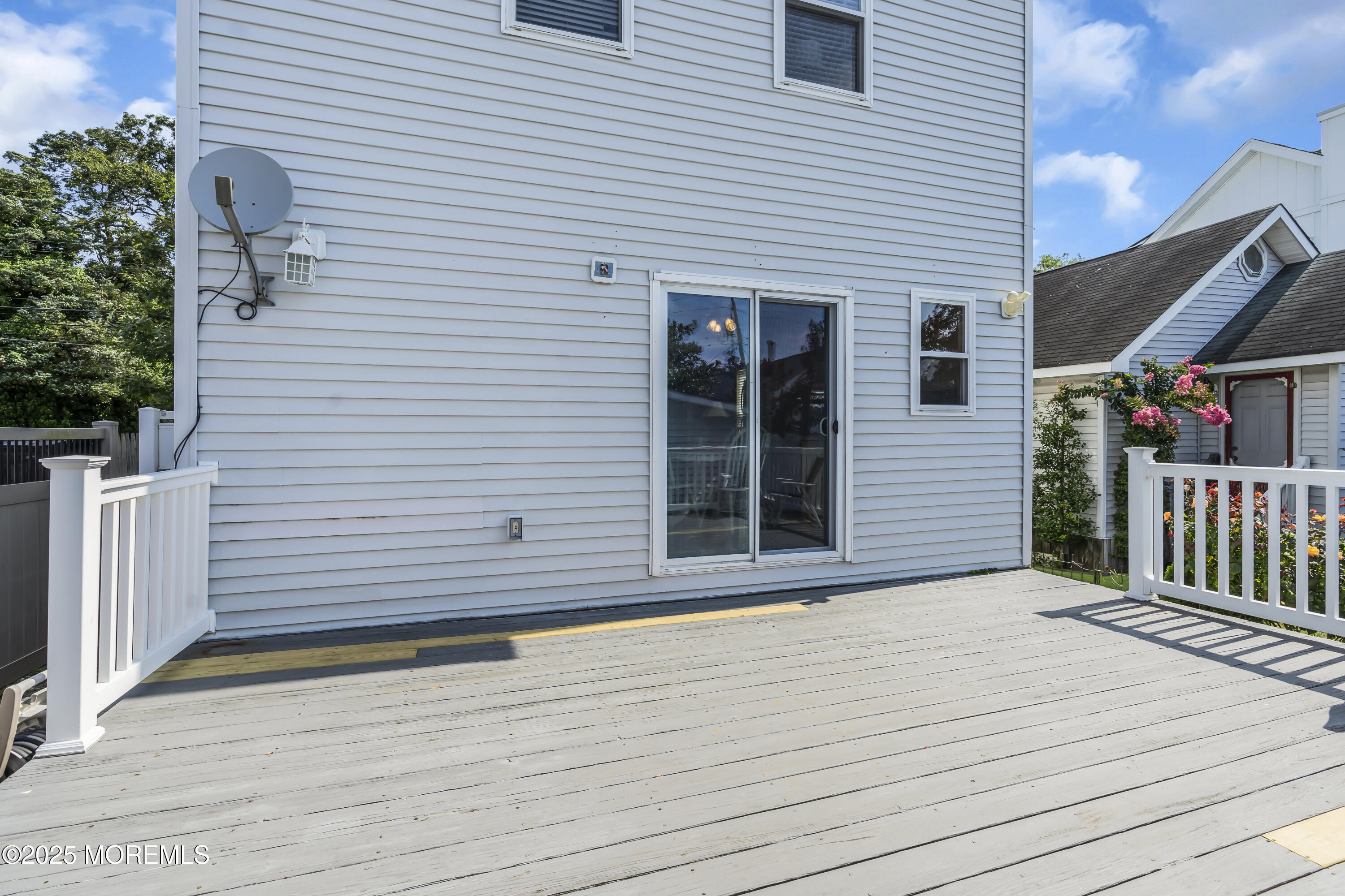 143 Lake Avenue Manasquan, NJ 08736 - Photo 7 of 18 a view of a brick house with wooden floor and fence