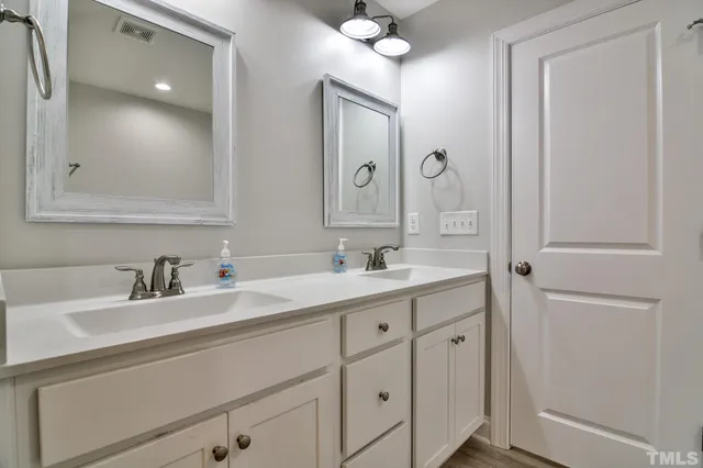 a en suite bathroom with a granite countertop sink and a mirror
