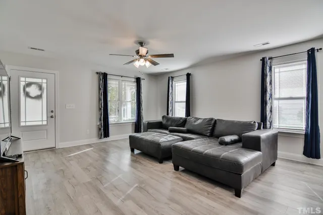 a living room with furniture and a flat screen tv with wooden floor