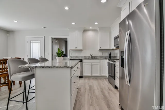 a kitchen with stainless steel appliances granite countertop a stove microwave and sink