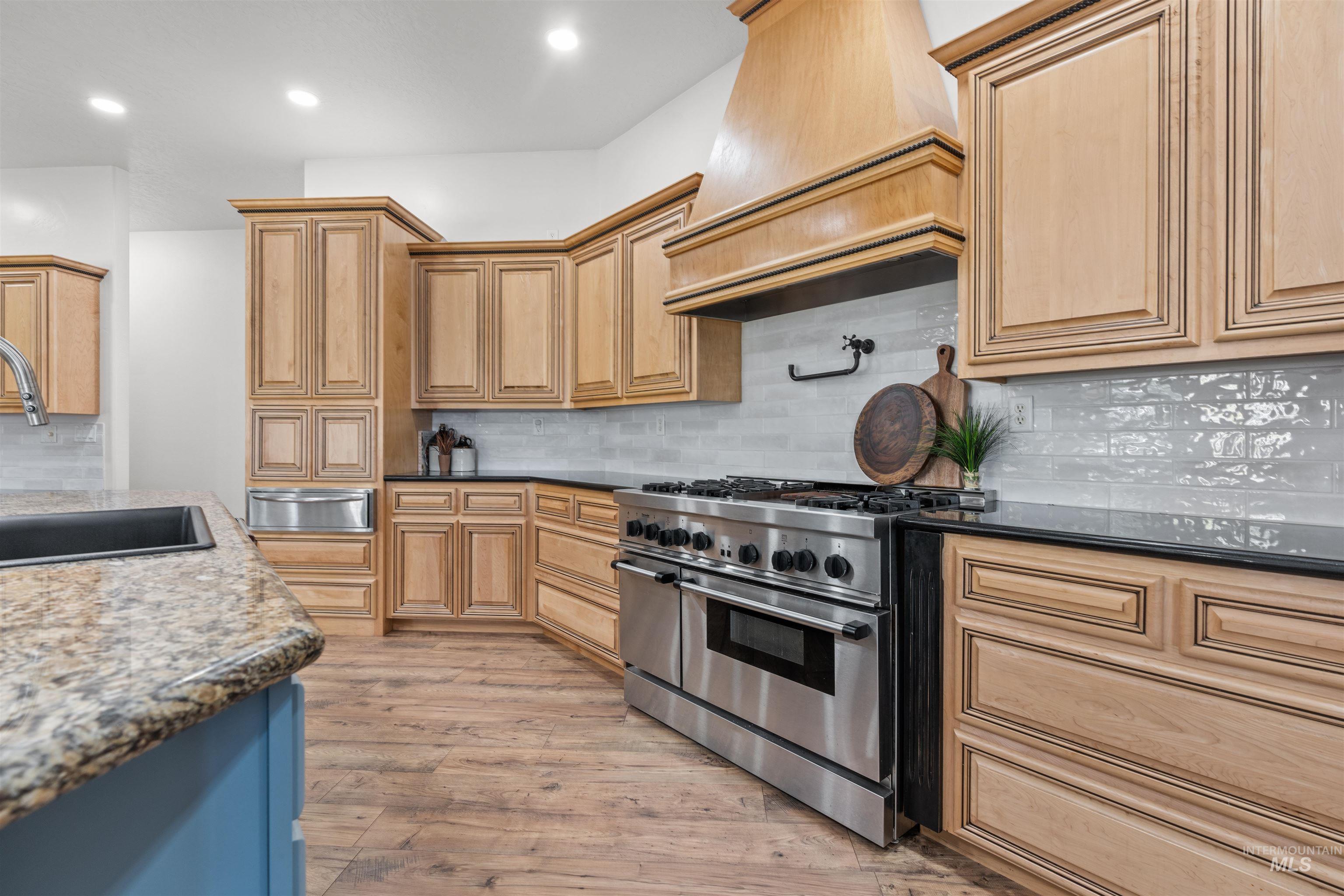 28279 Pearl Road Parma, ID 83660 - Photo 14 of 48 Kitchen with backsplash, dark stone countertops, range with two ovens, light wood finished floors, and recessed lighting