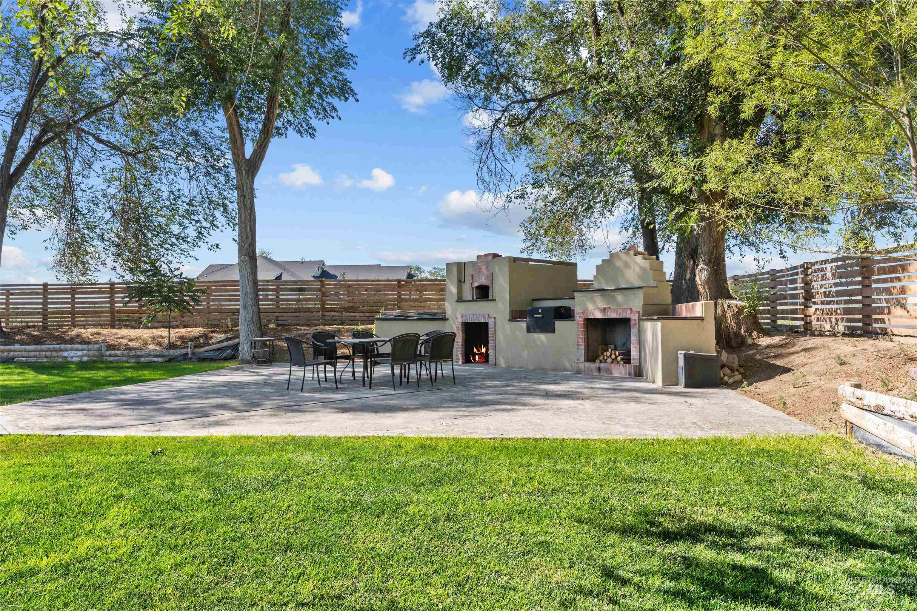 28279 Pearl Road Parma, ID 83660 - Photo 22 of 48 Fenced backyard with a warm lit fireplace and a patio