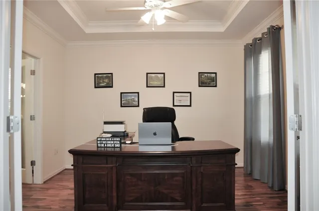 a view of a workspace with furniture and wooden floor
