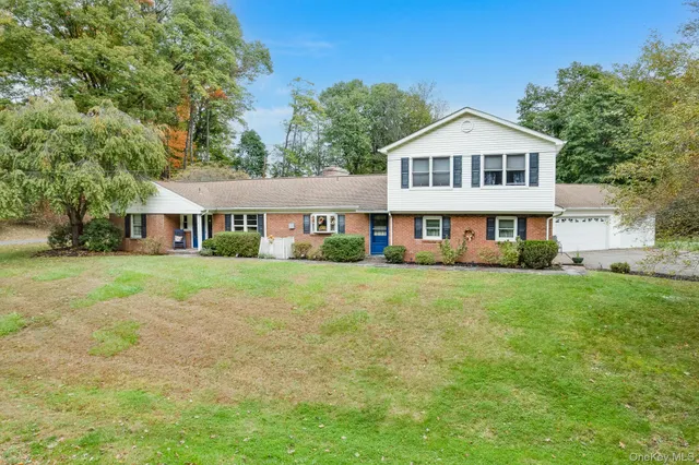 a front view of a house with a yard and trees