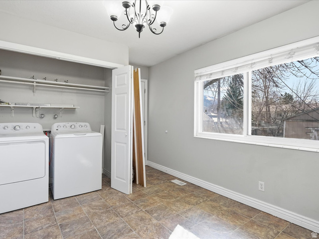 322 East 900 North Logan, UT 84321 - Photo 11 of 43 Laundry area featuring stone finish floors, washer and dryer, and a chandelier