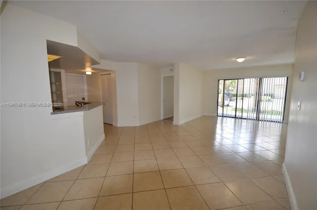 a view of a kitchen with an empty space and a window