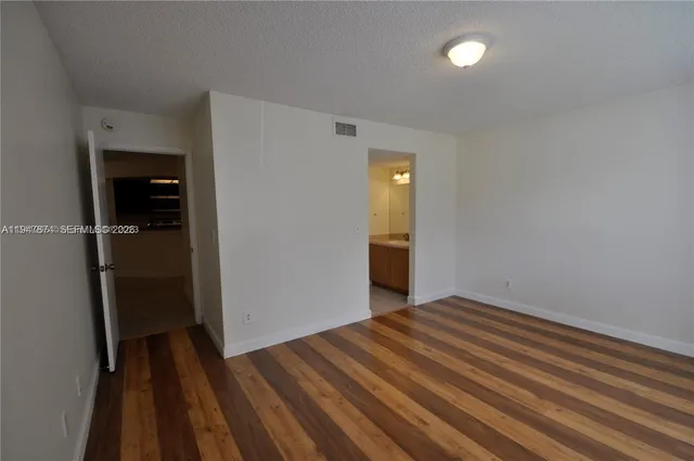 a view of a room with wooden floor and a hallway