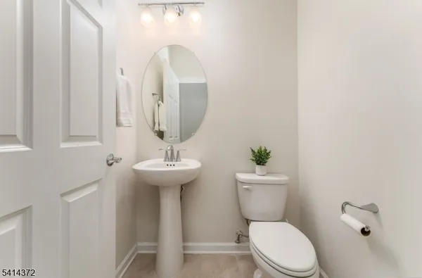 a bathroom with a toilet a sink and a mirror