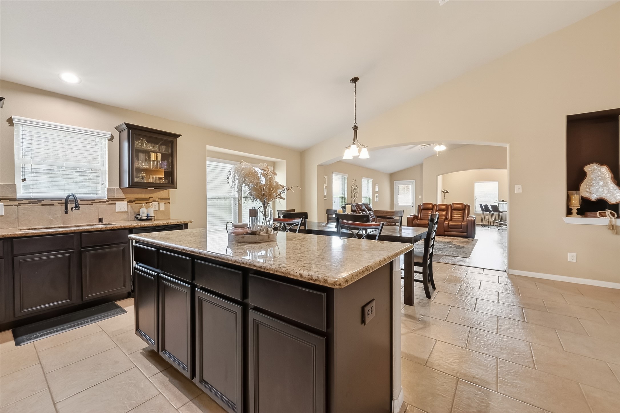 Open kitchen with a large island and clear view into the dining and living areas, creating a bright space that feels connected and easy to move through