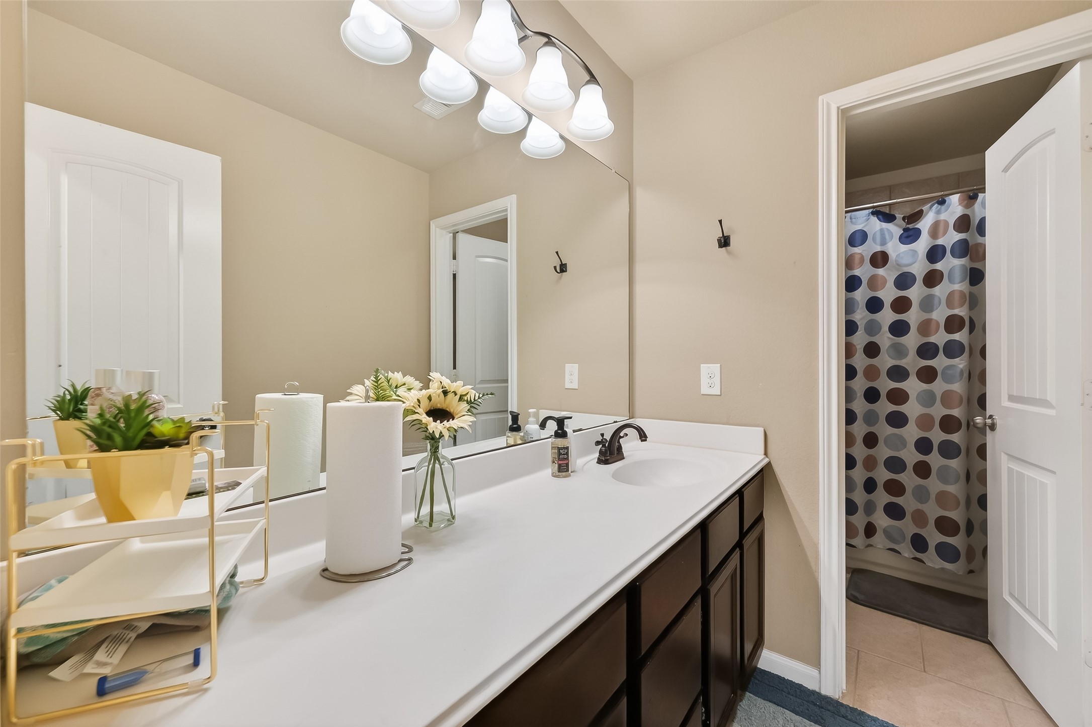 5919 Micah Lane Rosenberg, TX 77471 - Photo 27 of 32 Bathroom with a long vanity and ample counter space, offering plenty of room for storage. A wide mirror and bright lighting keep the space open and functional, while the layout provides easy flow into the adjoining bath area