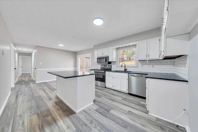 a kitchen with granite countertop a stove top oven sink and cabinets