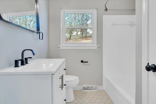 a bathroom with a sink a toilet and a window