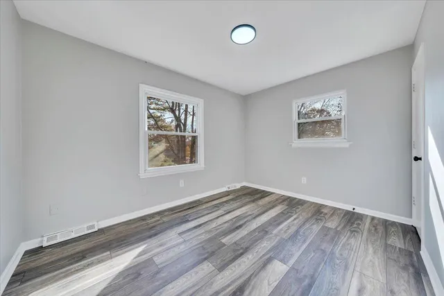 a view of room with window and wooden floor