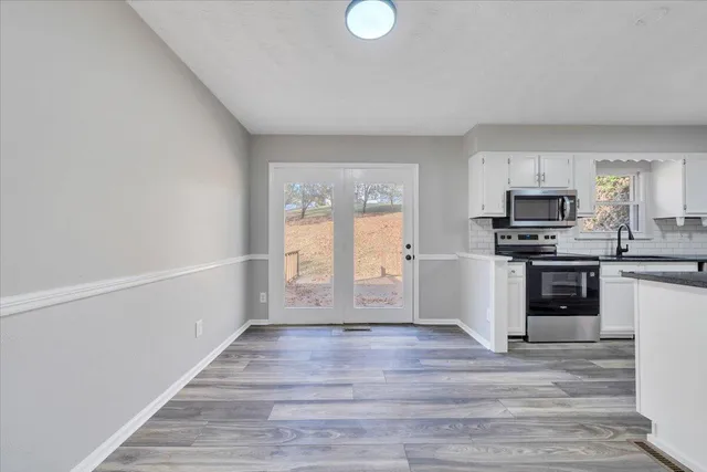 a kitchen with granite countertop a stove top oven and cabinets
