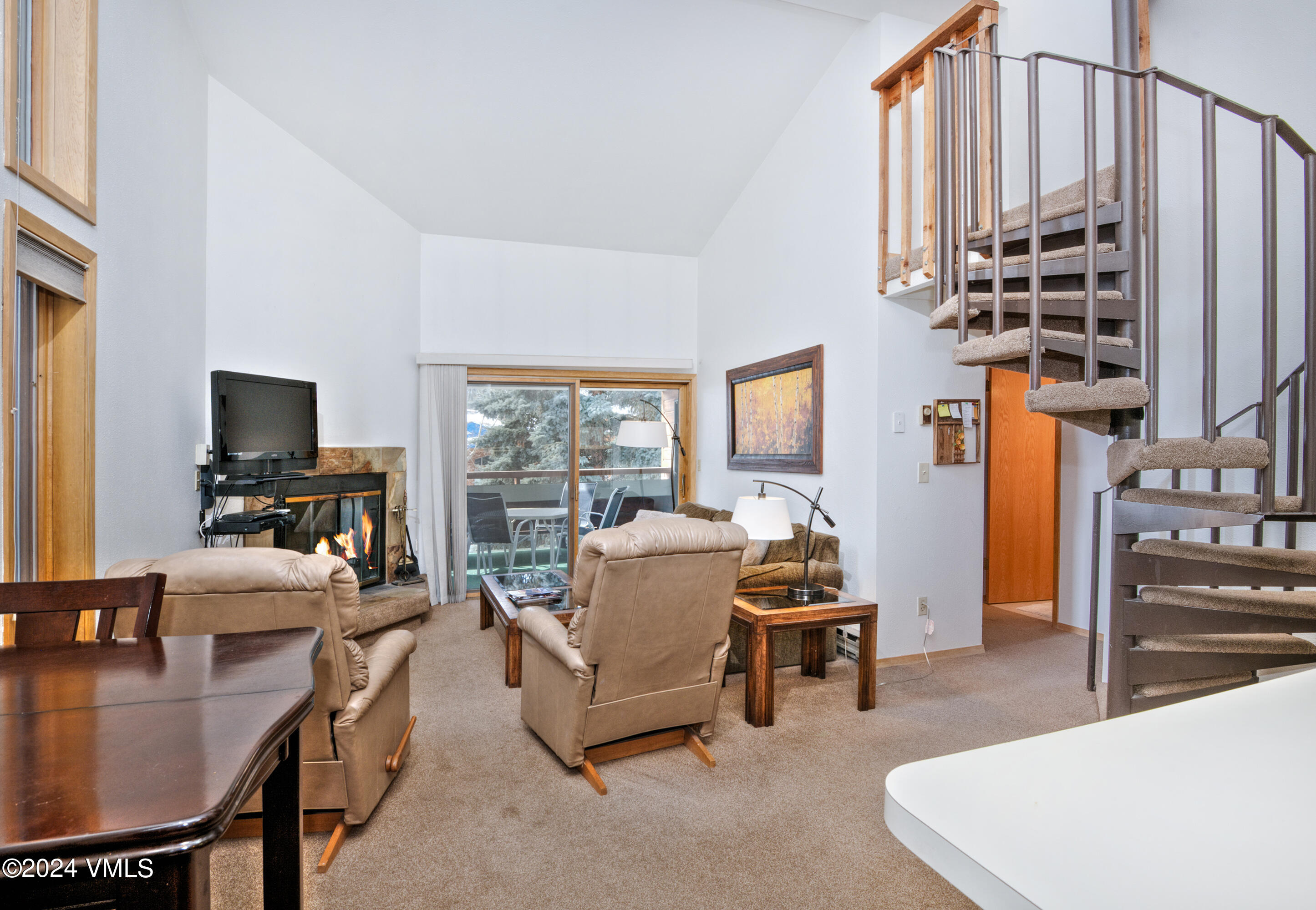 1030 Lions Ridge Loop, Unit 301 Vail, CO 81657 - Photo 4 of 28 a living room with furniture a flat screen tv and a table