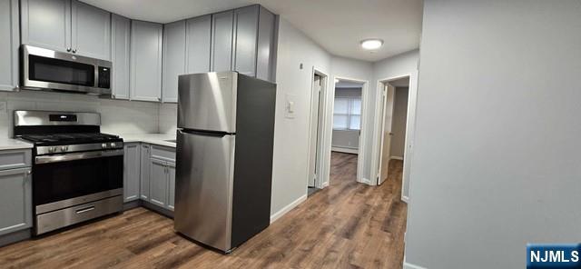a kitchen with stainless steel appliances granite countertop a refrigerator and a stove top oven