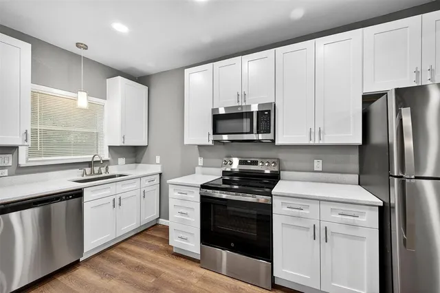 a kitchen with granite countertop white cabinets and white appliances