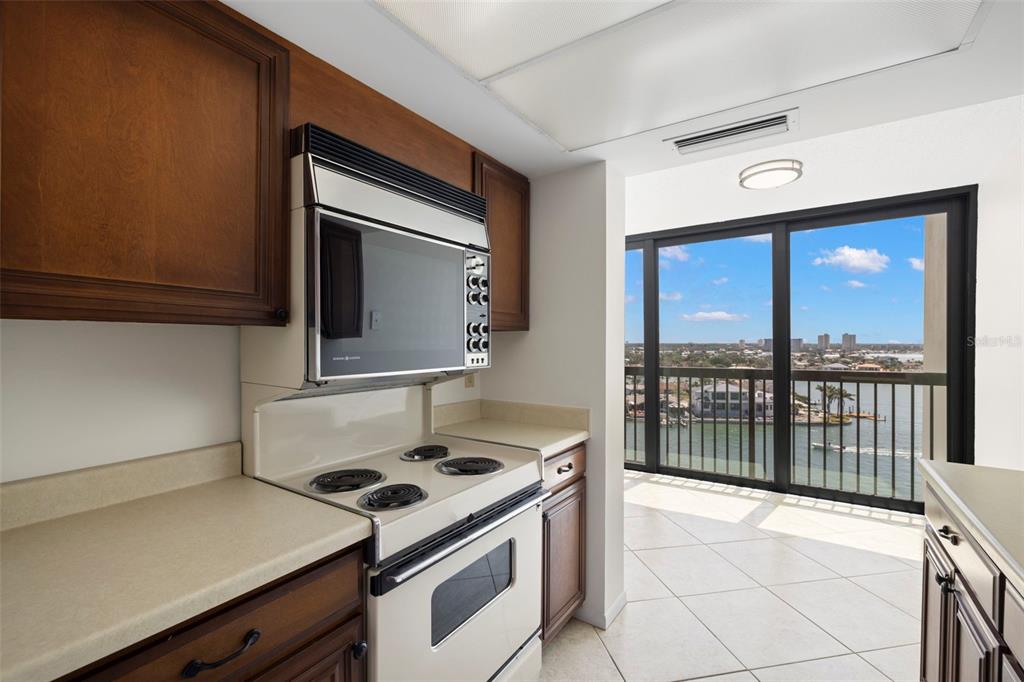 9425 Blind Pass Road, Unit 1008 St. Pete Beach, FL 33706 - Photo 14 of 65 a kitchen with a stove and a microwave
