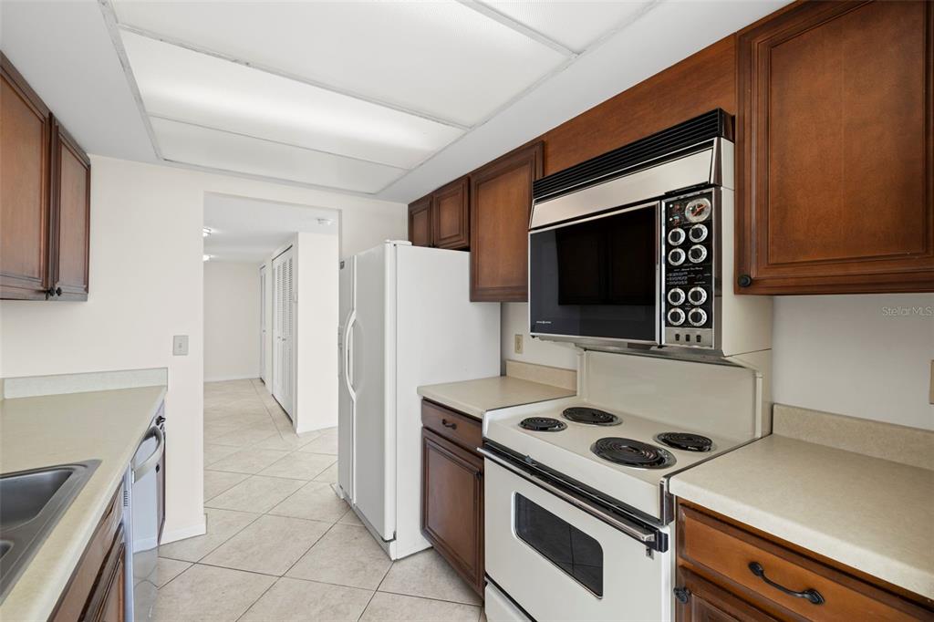 9425 Blind Pass Road, Unit 1008 St. Pete Beach, FL 33706 - Photo 16 of 65 a kitchen with a stove and a microwave