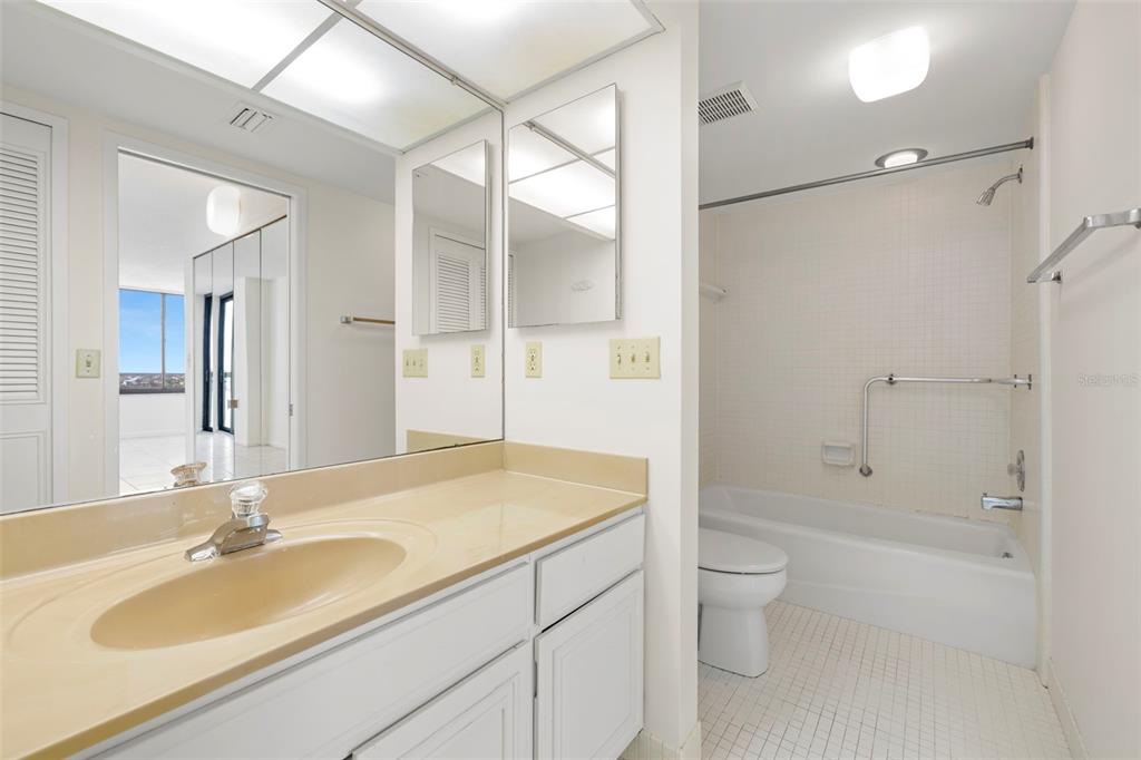 9425 Blind Pass Road, Unit 1008 St. Pete Beach, FL 33706 - Photo 24 of 65 a bathroom with a sink a toilet and shower