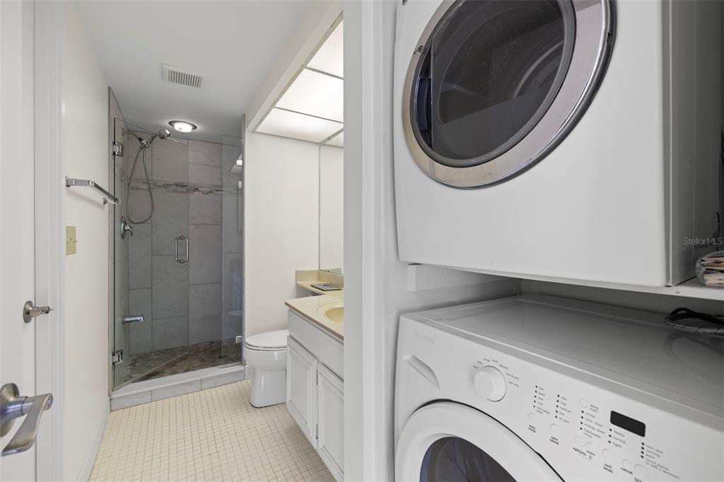 9425 Blind Pass Road, Unit 1008 St. Pete Beach, FL 33706 - Photo 26 of 65 a view of a bathroom with a washer and dryer