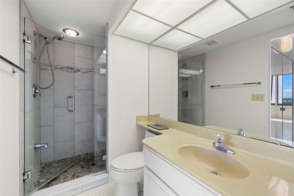 9425 Blind Pass Road, Unit 1008 St. Pete Beach, FL 33706 - Photo 27 of 65 a bathroom with a sink toilet and shower