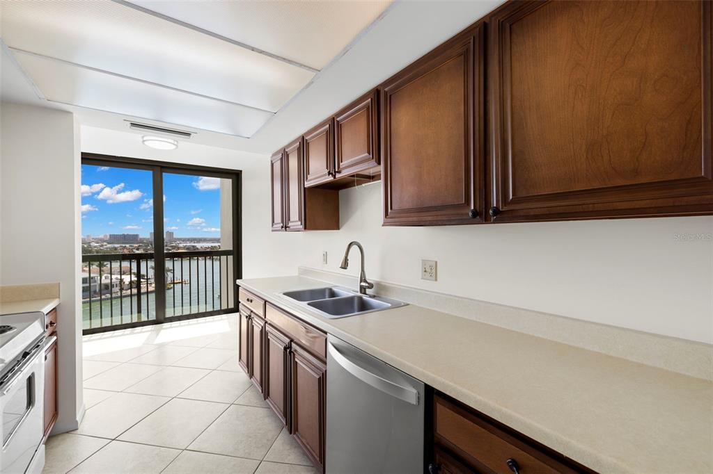 9425 Blind Pass Road, Unit 1008 St. Pete Beach, FL 33706 - Photo 4 of 65 a kitchen with stainless steel appliances granite countertop a sink stove and cabinets