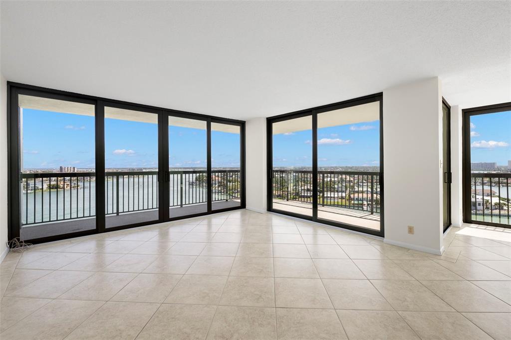 9425 Blind Pass Road, Unit 1008 St. Pete Beach, FL 33706 - Photo 8 of 65 a view of an empty room with a balcony and large windows