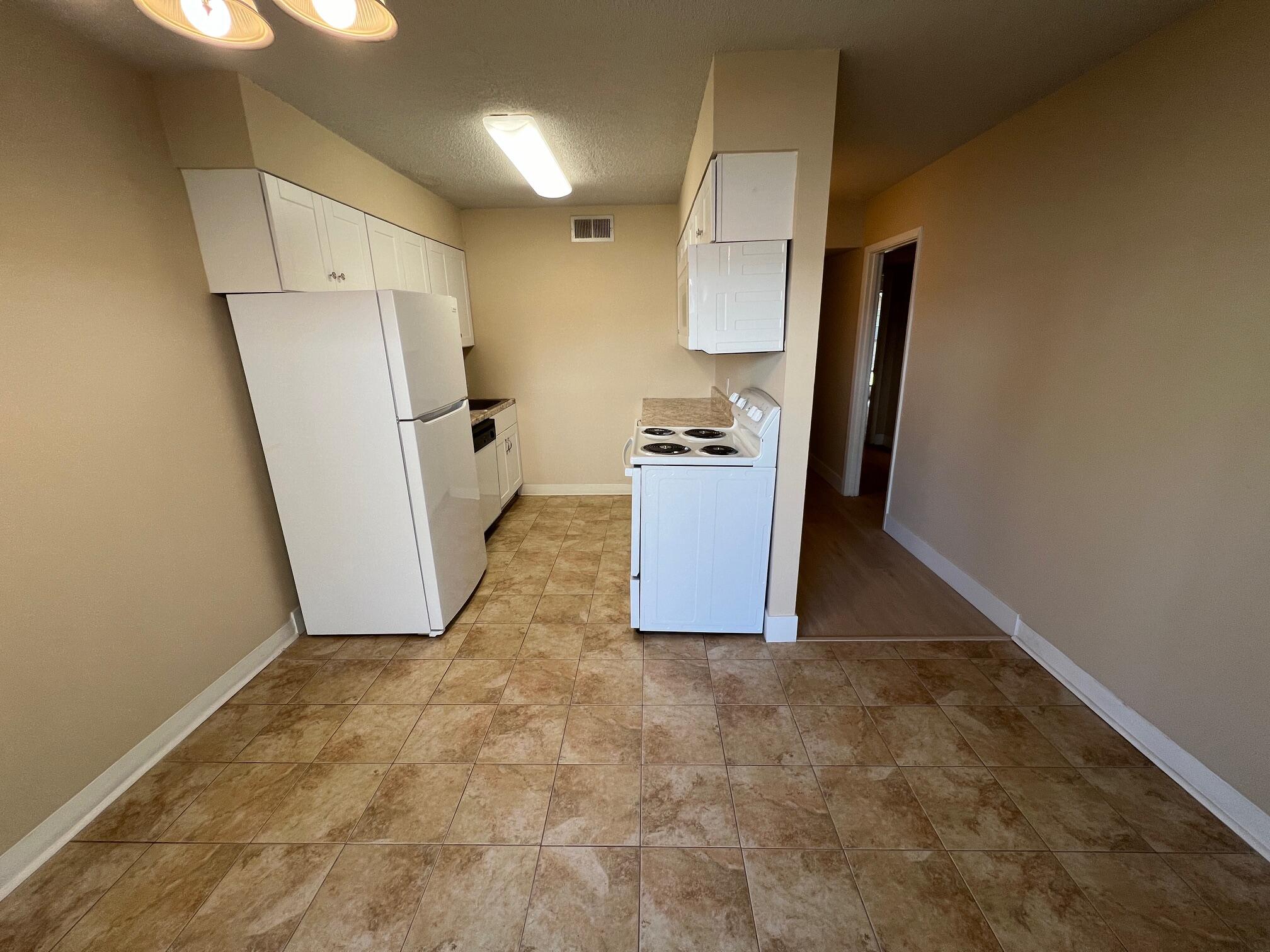 210 Pelham Road, Unit 105B Fort Walton Beach, FL 32547 - Photo 13 of 41 a view of a kitchen with refrigerator and a sink