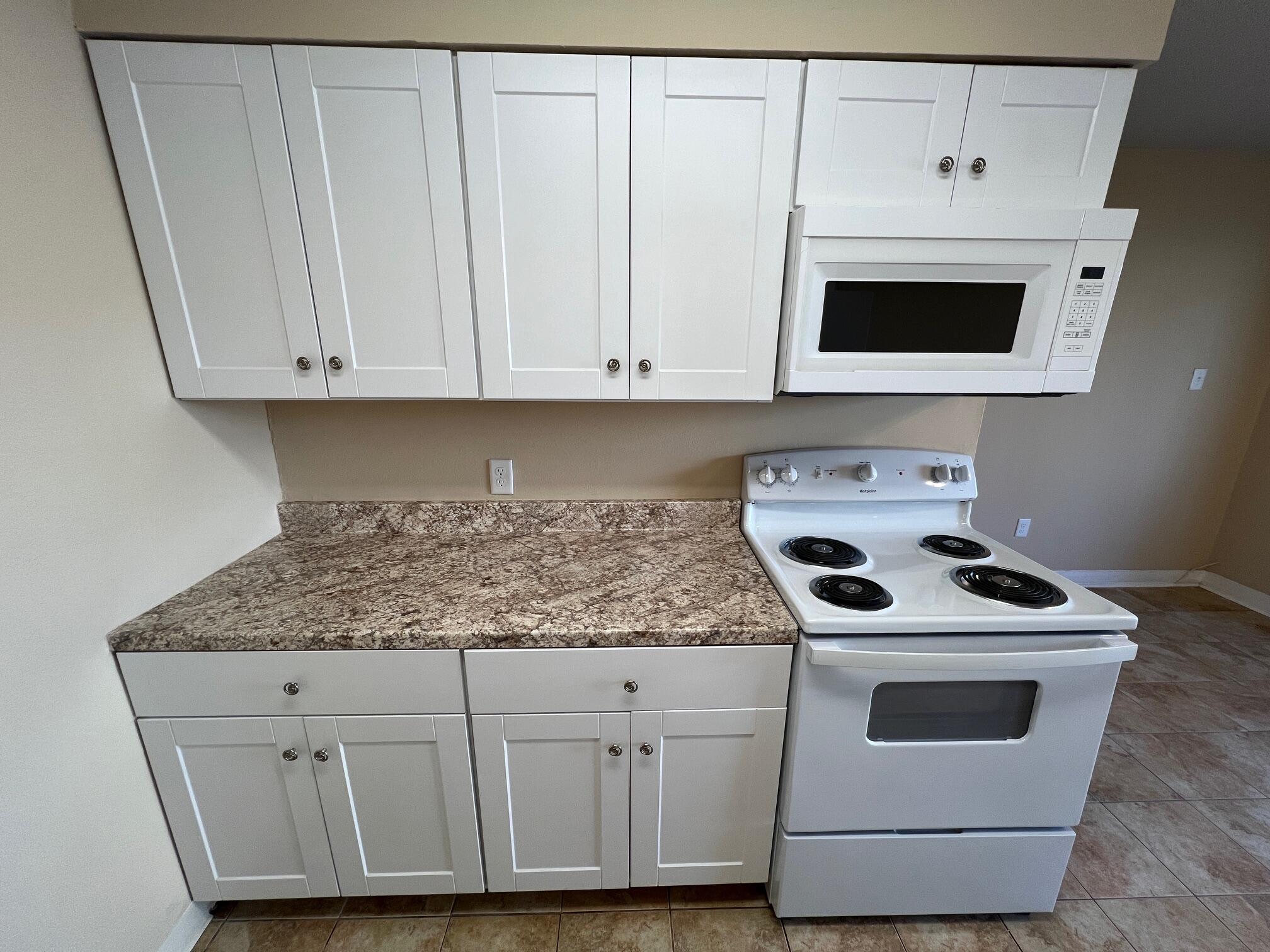 210 Pelham Road, Unit 105B Fort Walton Beach, FL 32547 - Photo 15 of 41 a kitchen with granite countertop white cabinets and white stove