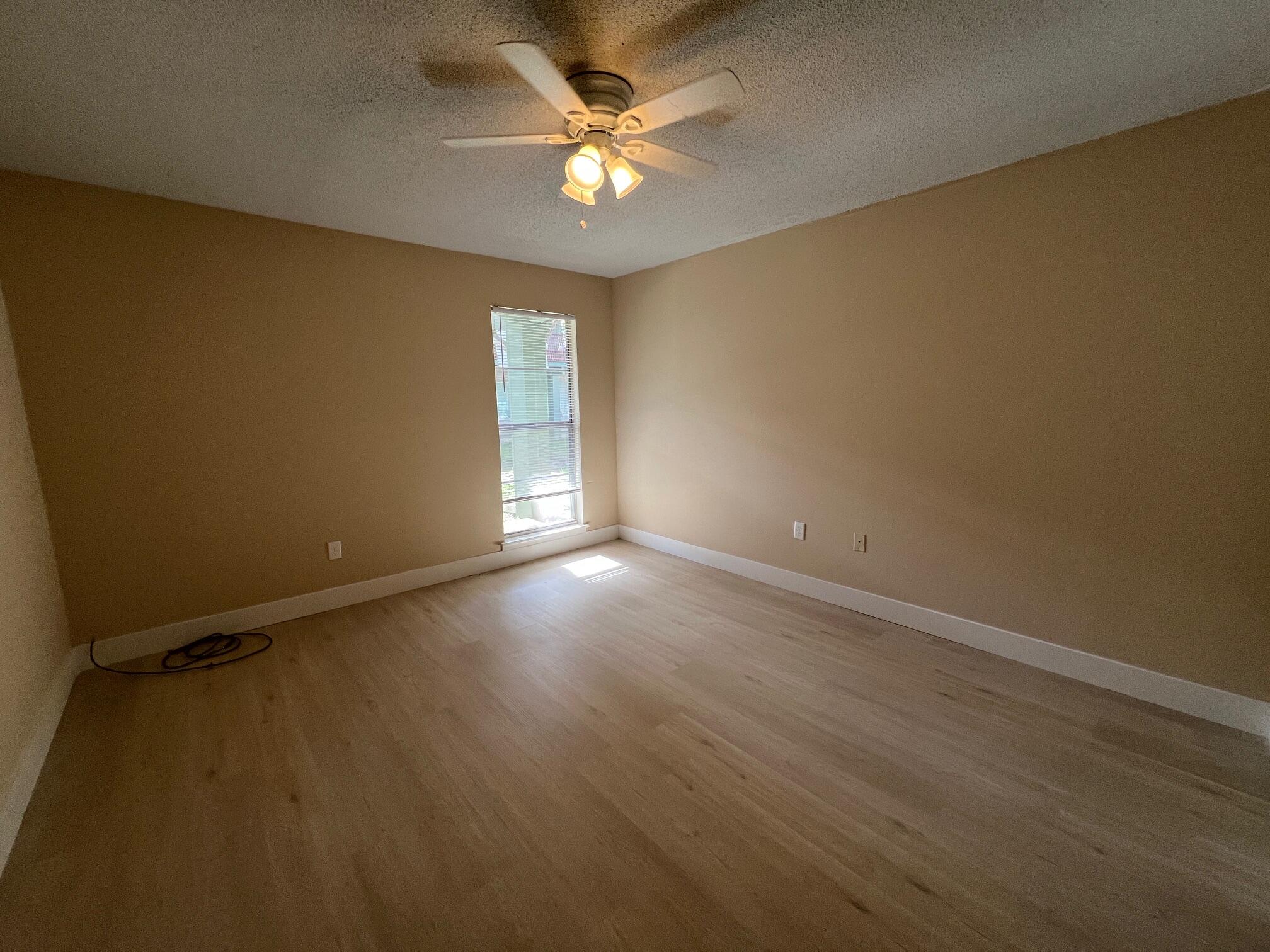 210 Pelham Road, Unit 105B Fort Walton Beach, FL 32547 - Photo 21 of 41 an empty room with a windows and a ceiling fan