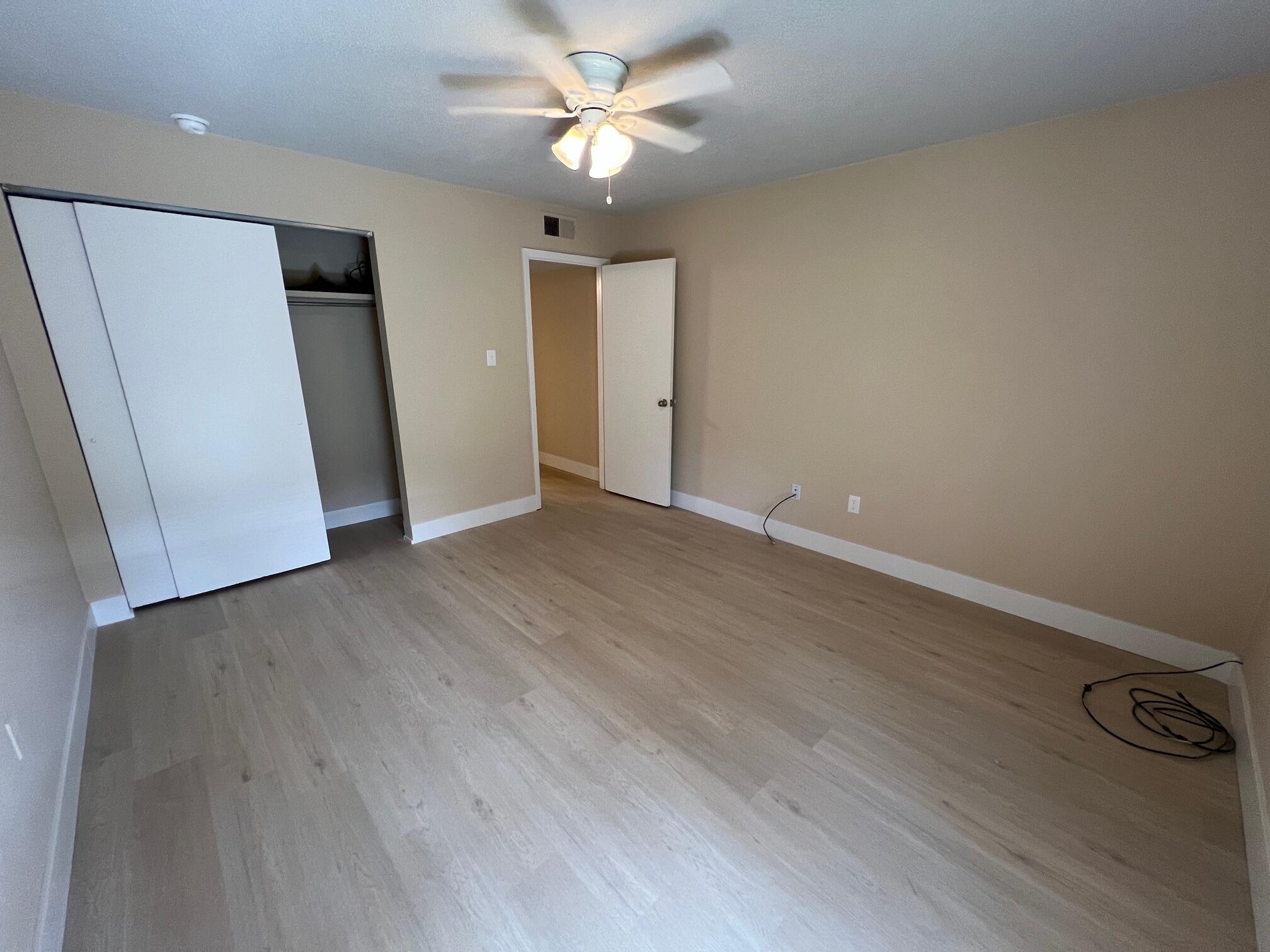 210 Pelham Road, Unit 105B Fort Walton Beach, FL 32547 - Photo 22 of 41 an empty room with wooden floor and ceiling fan