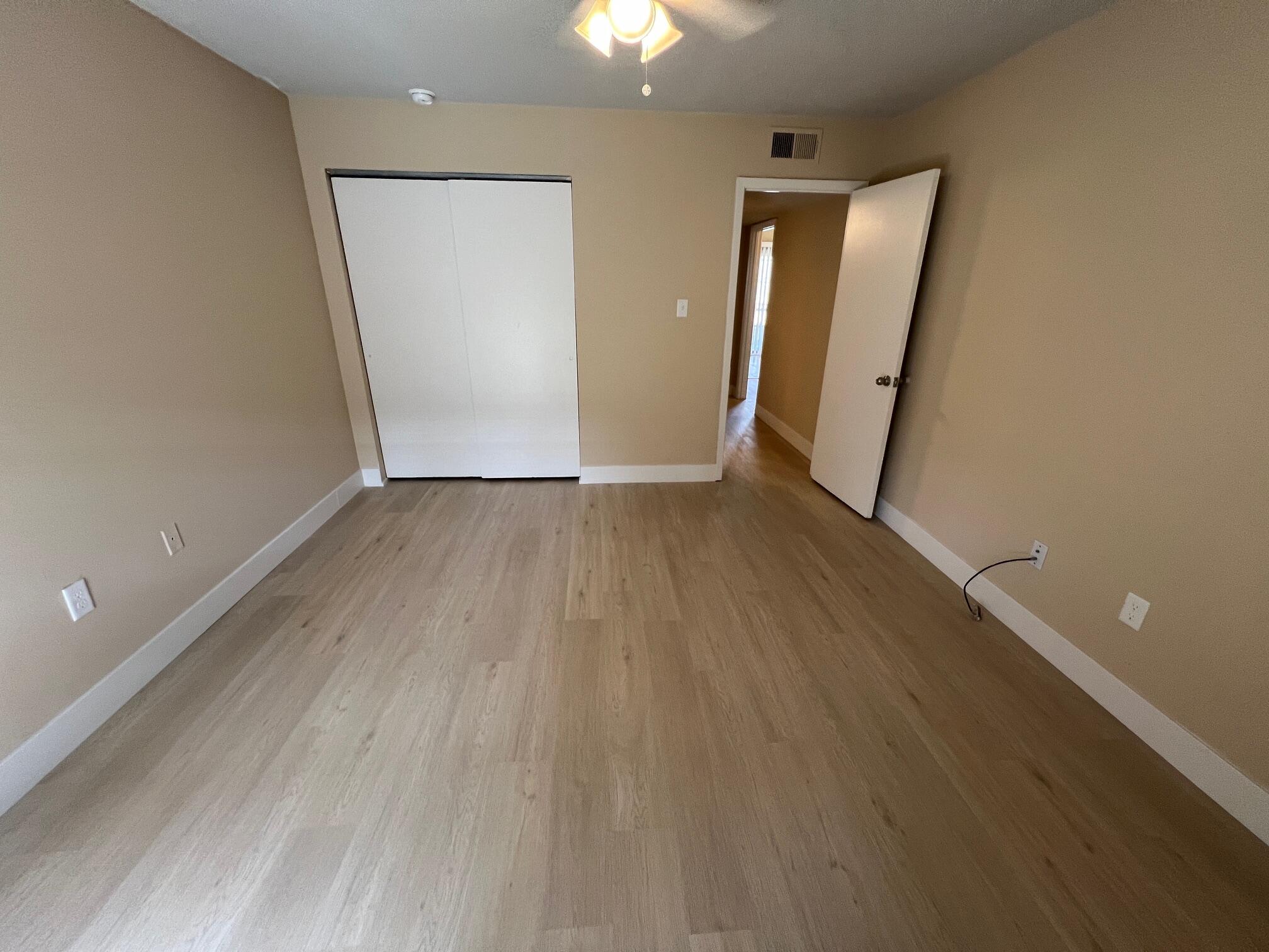 210 Pelham Road, Unit 105B Fort Walton Beach, FL 32547 - Photo 23 of 41 an empty room with wooden floor and windows
