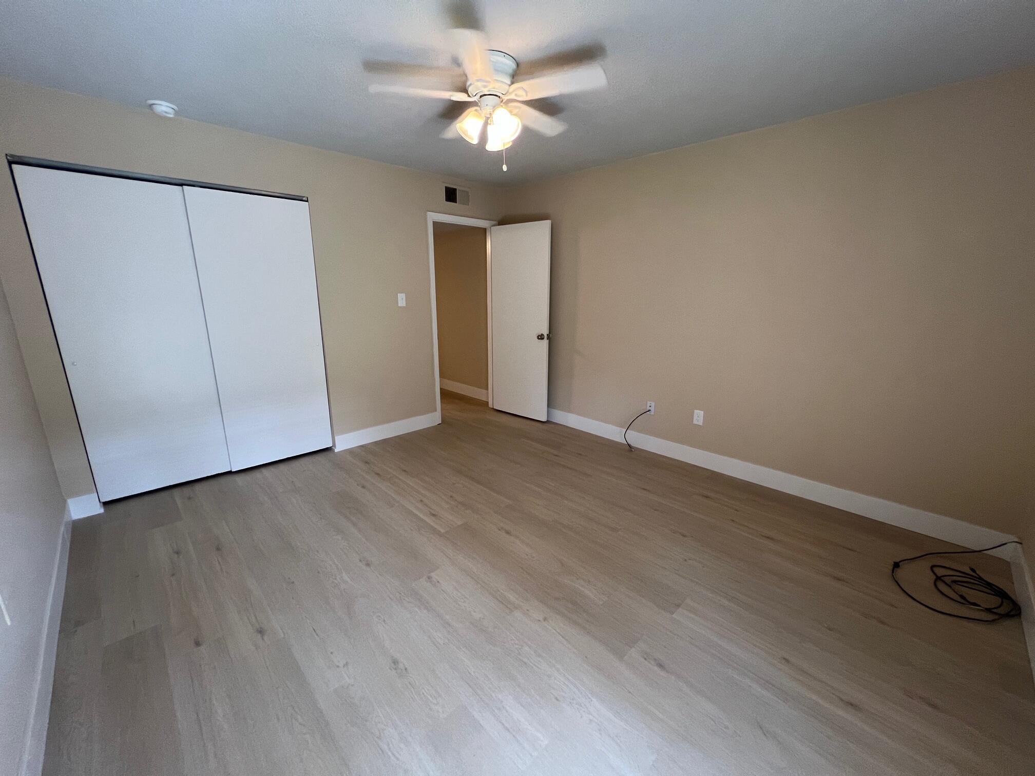 210 Pelham Road, Unit 105B Fort Walton Beach, FL 32547 - Photo 24 of 41 an empty room with wooden floor and fan