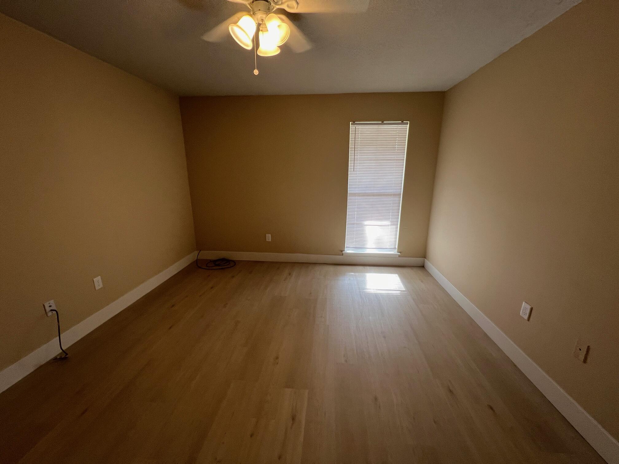 210 Pelham Road, Unit 105B Fort Walton Beach, FL 32547 - Photo 28 of 41 an empty room with wooden floor and windows