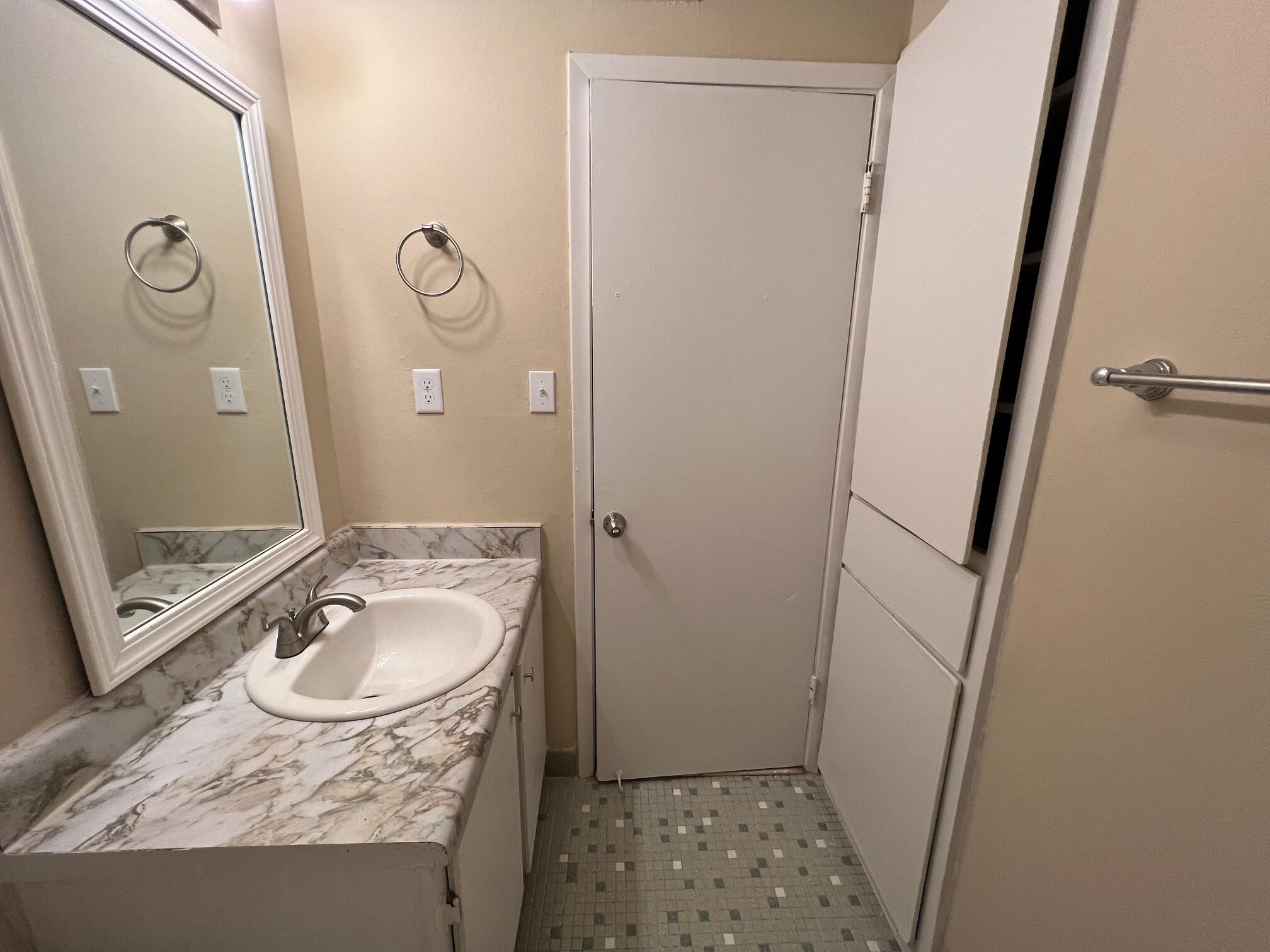 210 Pelham Road, Unit 105B Fort Walton Beach, FL 32547 - Photo 30 of 41 a bathroom with a granite countertop sink toilet and shower a mirror