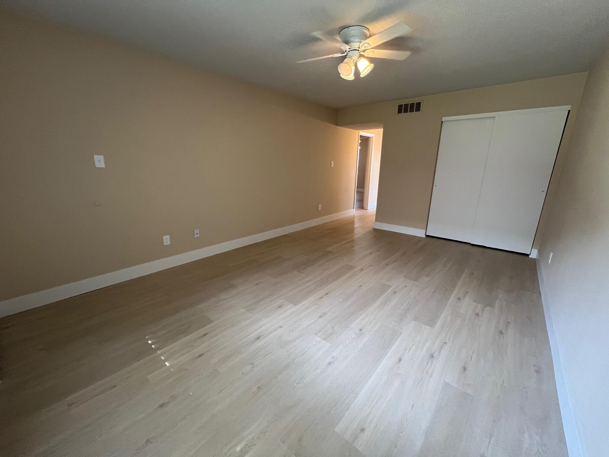 210 Pelham Road, Unit 105B Fort Walton Beach, FL 32547 - Photo 8 of 41 an empty room with wooden floor and ceiling fan