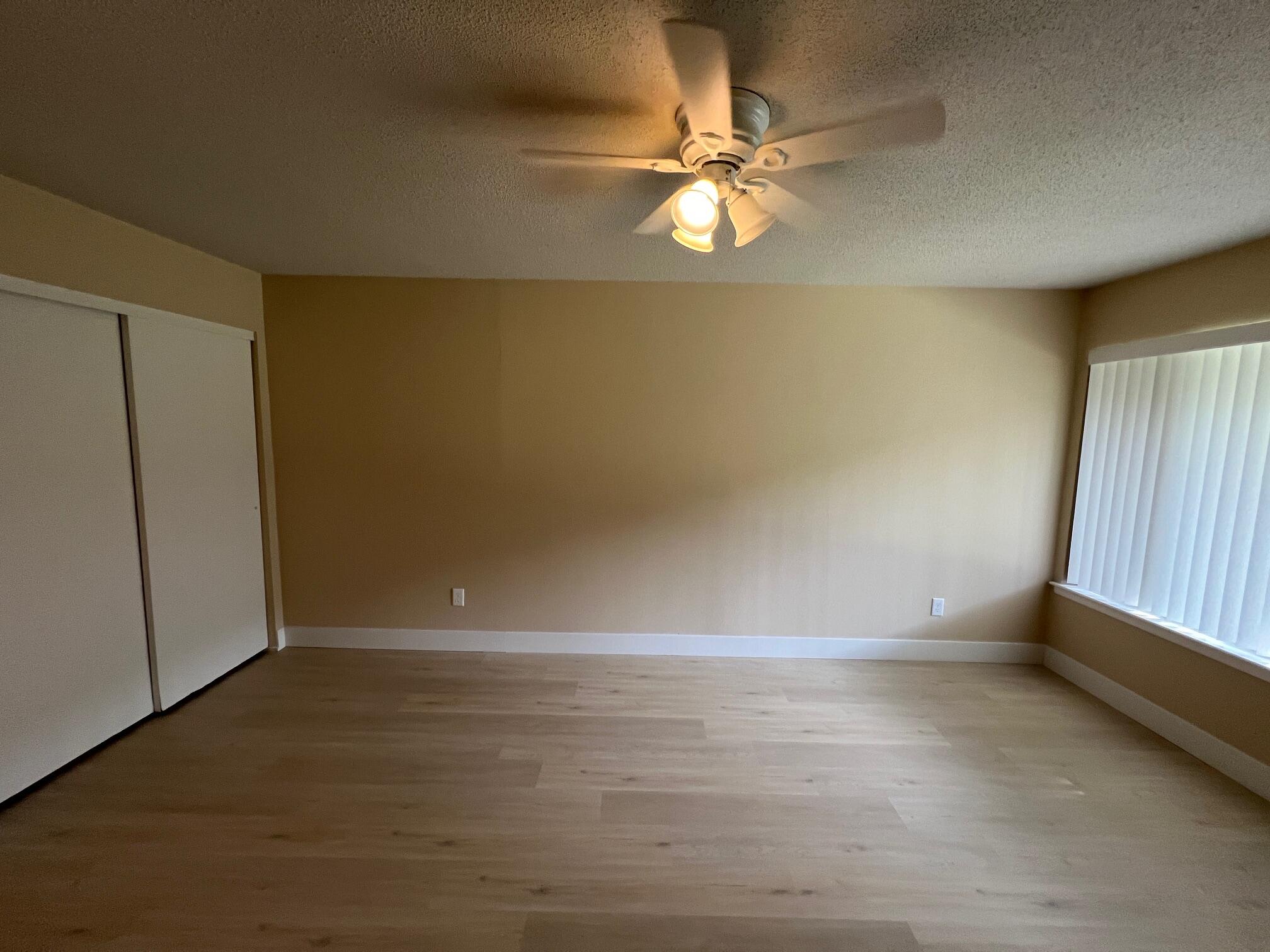 210 Pelham Road, Unit 105B Fort Walton Beach, FL 32547 - Photo 9 of 41 wooden floor in an empty room with a window
