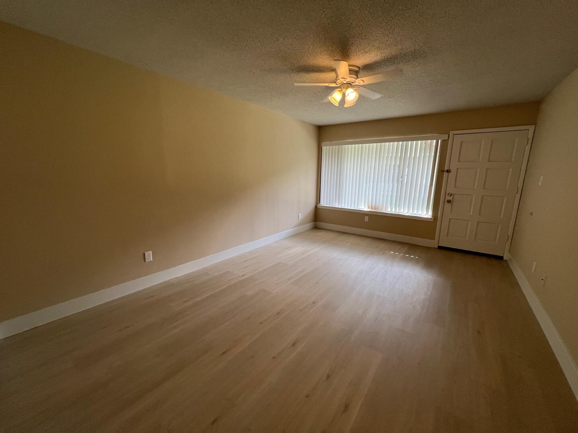 210 Pelham Road, Unit 105B Fort Walton Beach, FL 32547 - Photo 10 of 41 a view of an empty room with wooden floor and a window