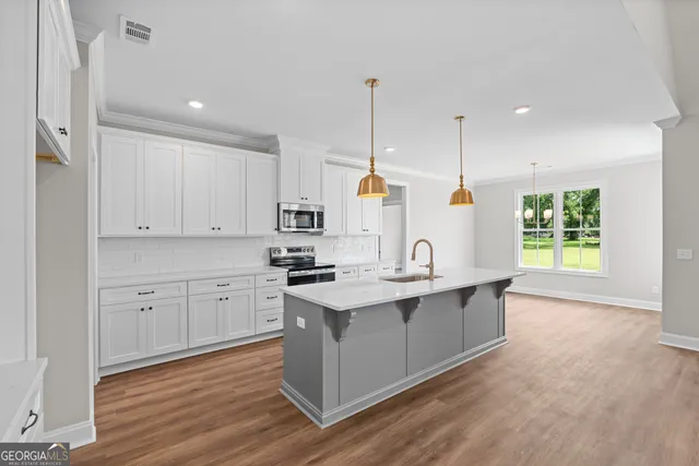 a kitchen with white cabinets and sink