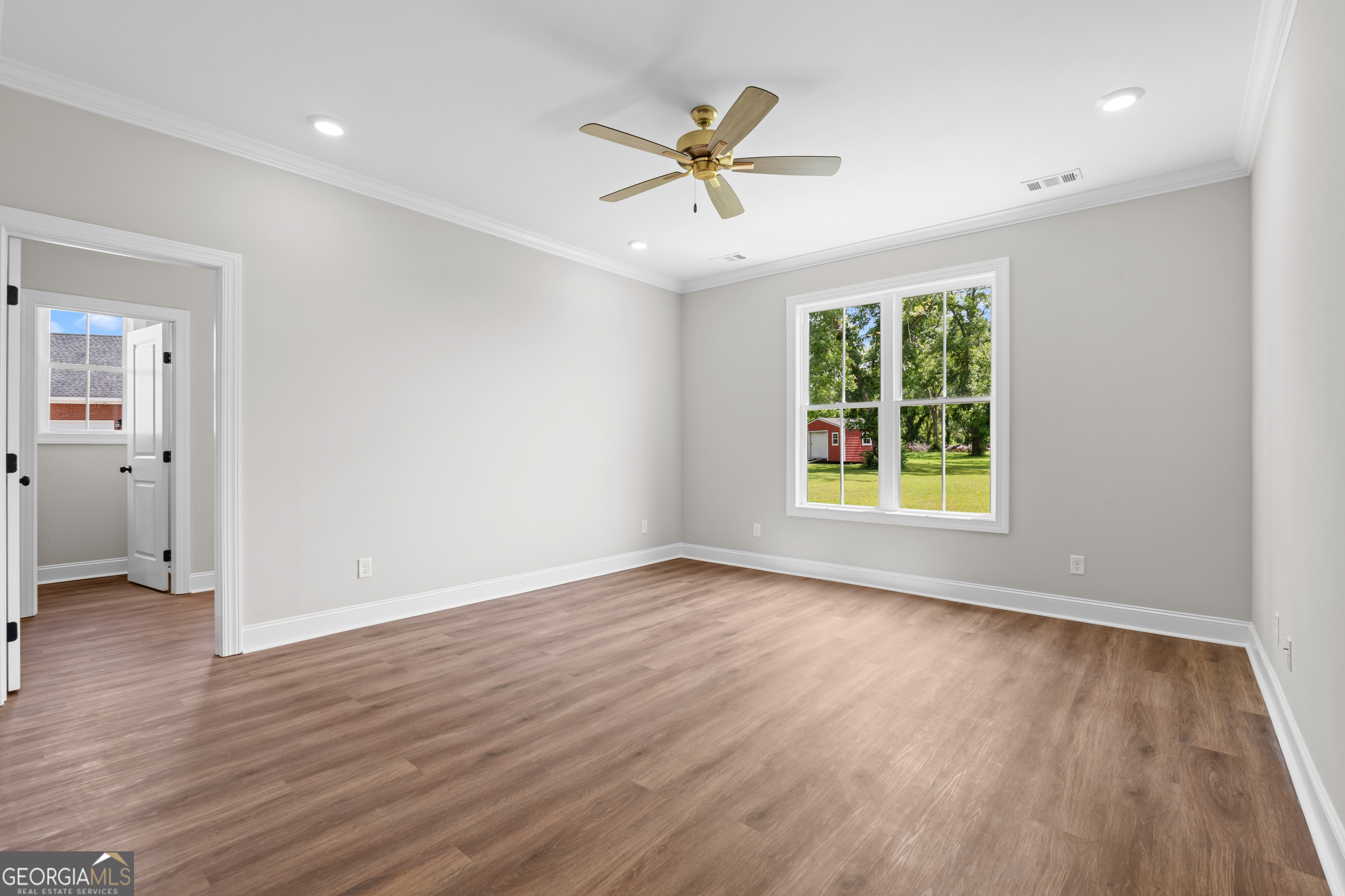9 Honeysuckle Way Claxton, GA 30417 - Photo 18 of 46 an empty room with wooden floor a ceiling fan and windows