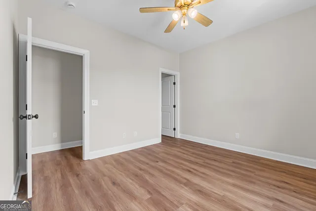 a view of a house next to a big yard with plants and large trees