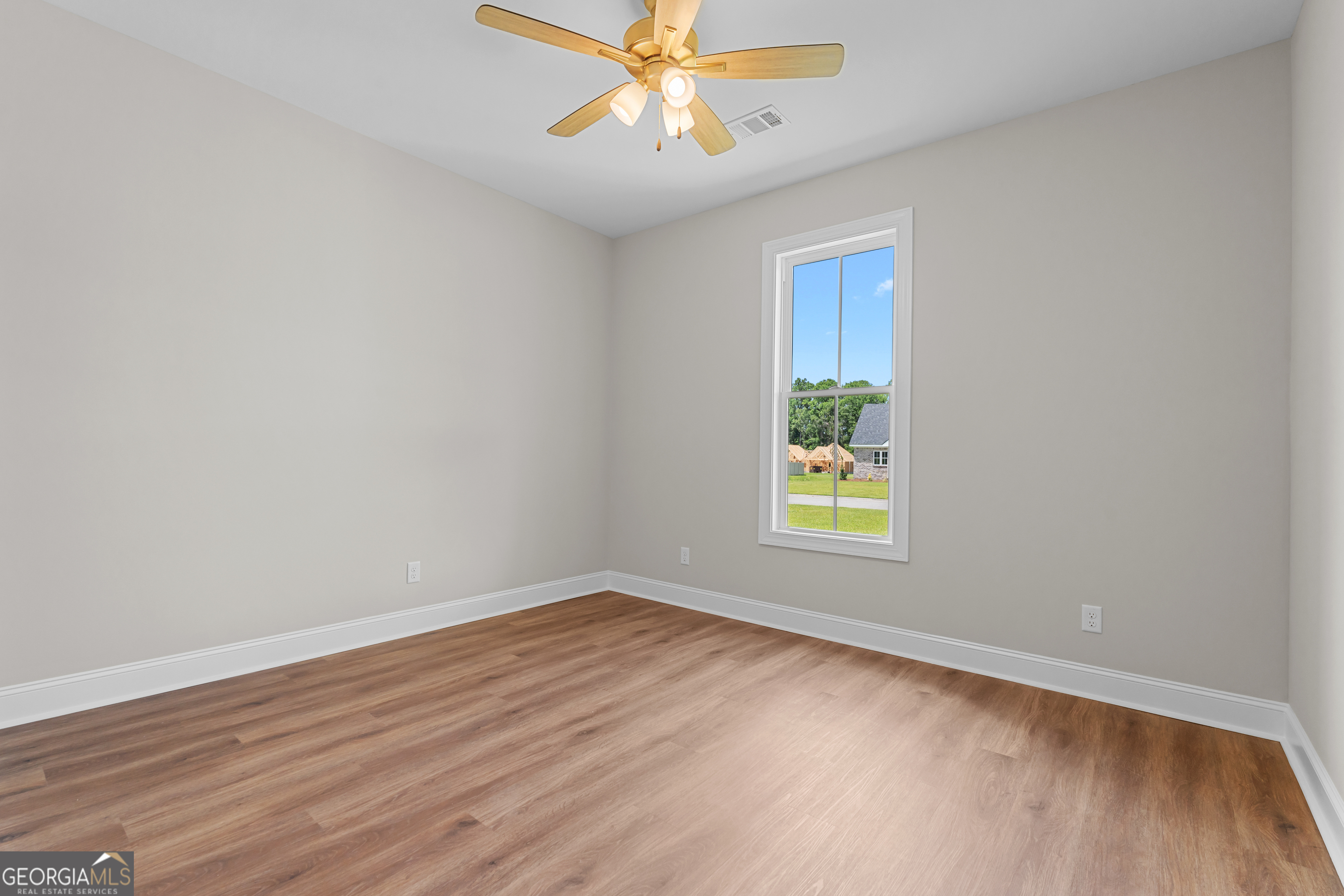 9 Honeysuckle Way Claxton, GA 30417 - Photo 27 of 46 a view of an empty room with window and wooden floor