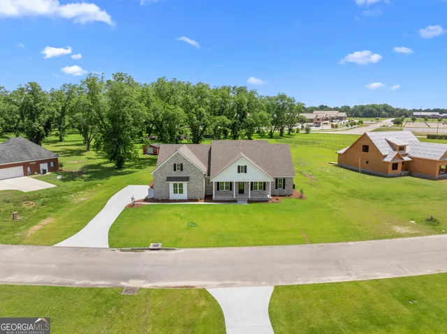 an aerial view of a house with a garden and swimming pool