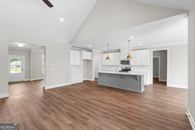 a large kitchen with kitchen island a sink stainless steel appliances and cabinets
