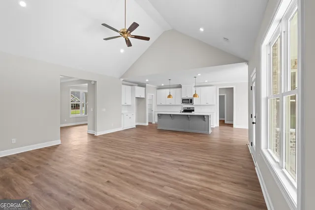 a view of empty room with wooden floor and ceiling fan